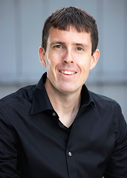 Portrait photo of a smiling man in a black shirt