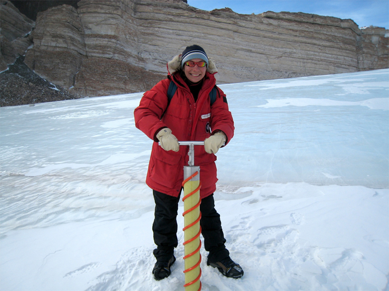Researcher Margarita Marinova uses an auger to drill a core from the ice pack at University Valley in the McMurdo Dry Valleys, Antarctica.