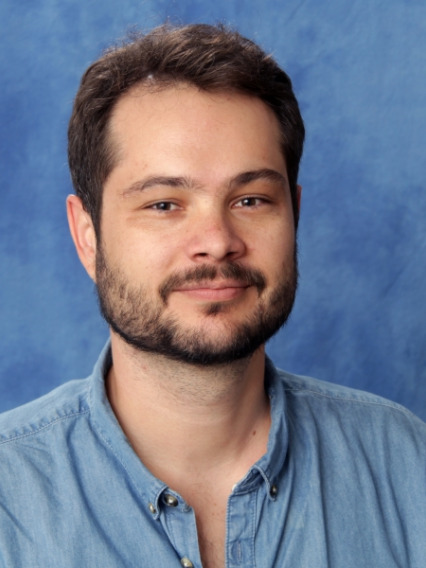 Portrait photo of a man with a short dark beard and mustache