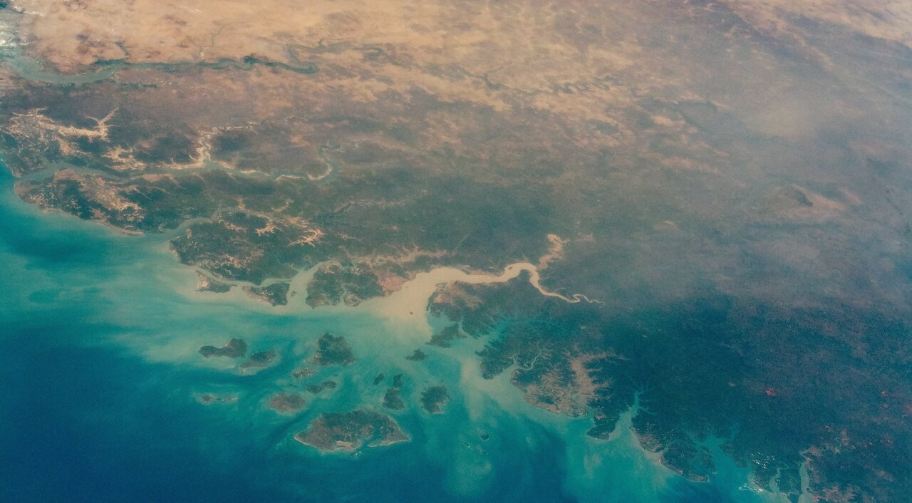 Photo of West African coast from space, showing turquoise water, green coastal areas and tan desert.