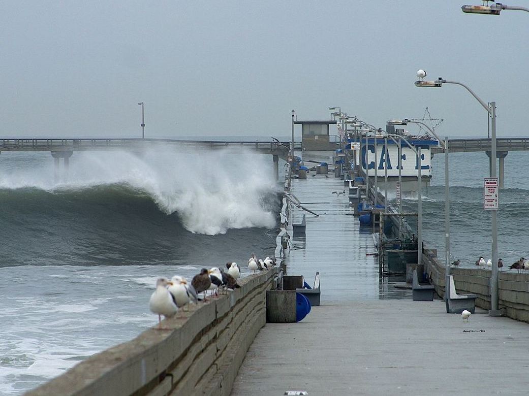 A big wave crashing over a pier in San Diego during the 2002 El Nino