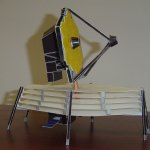 A view of a paper model of the James Webb Space Telescope standing on a desk table.