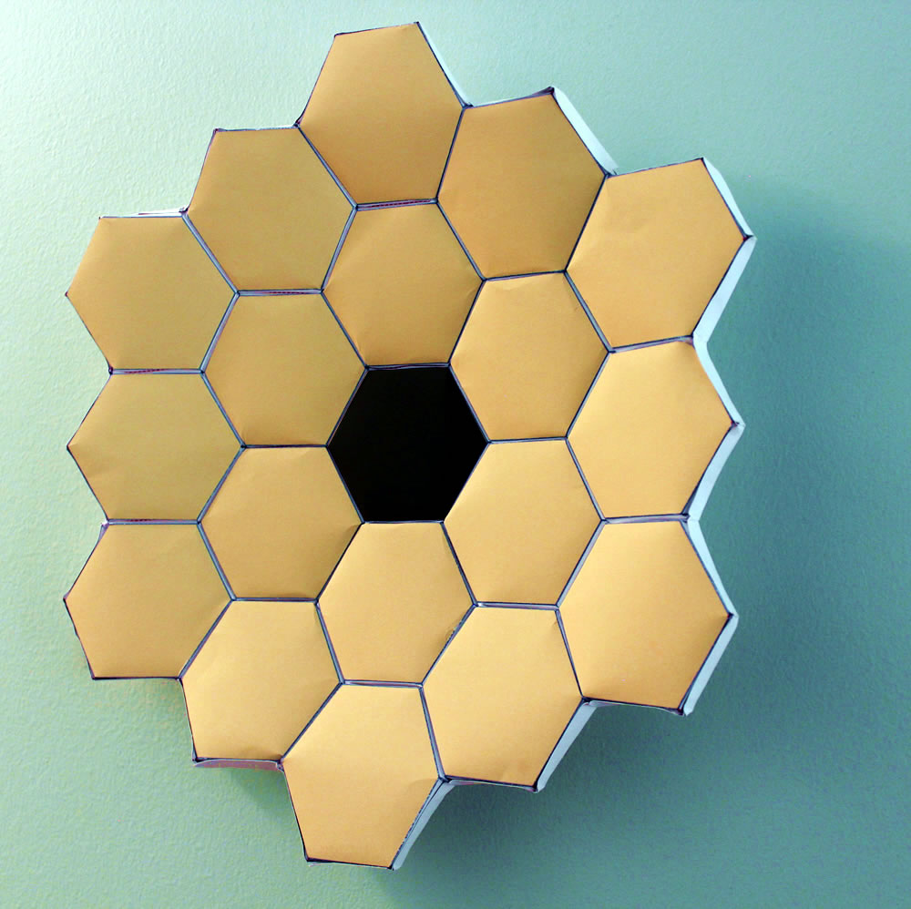 Example of a front view of the Webb Mirror Origami showing the 18 gold Webb hexagon mirror segments with a black hexagon in the middle.