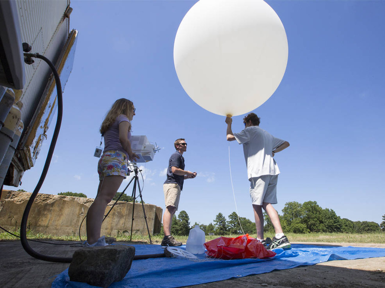 NASA Goddard post-doctoral fellow John Sullivan, center, along with interns Lindsay Rodeo, left, and Lance Nino, prepare to launch a balloon that will take ozone measurements in the skies over southeastern Virginia.