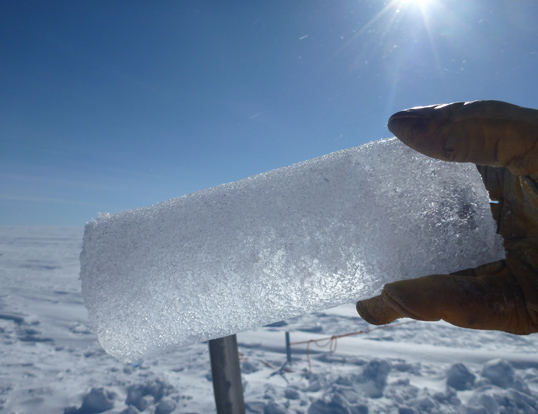 An ice core segment extracted from the aquifer, with trapped water collecting at the lower left of the core. Credit: NASA's Goddard Space Flight Center/Ludovic Brucker.