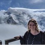 blonde woman standing by railing at mountain top