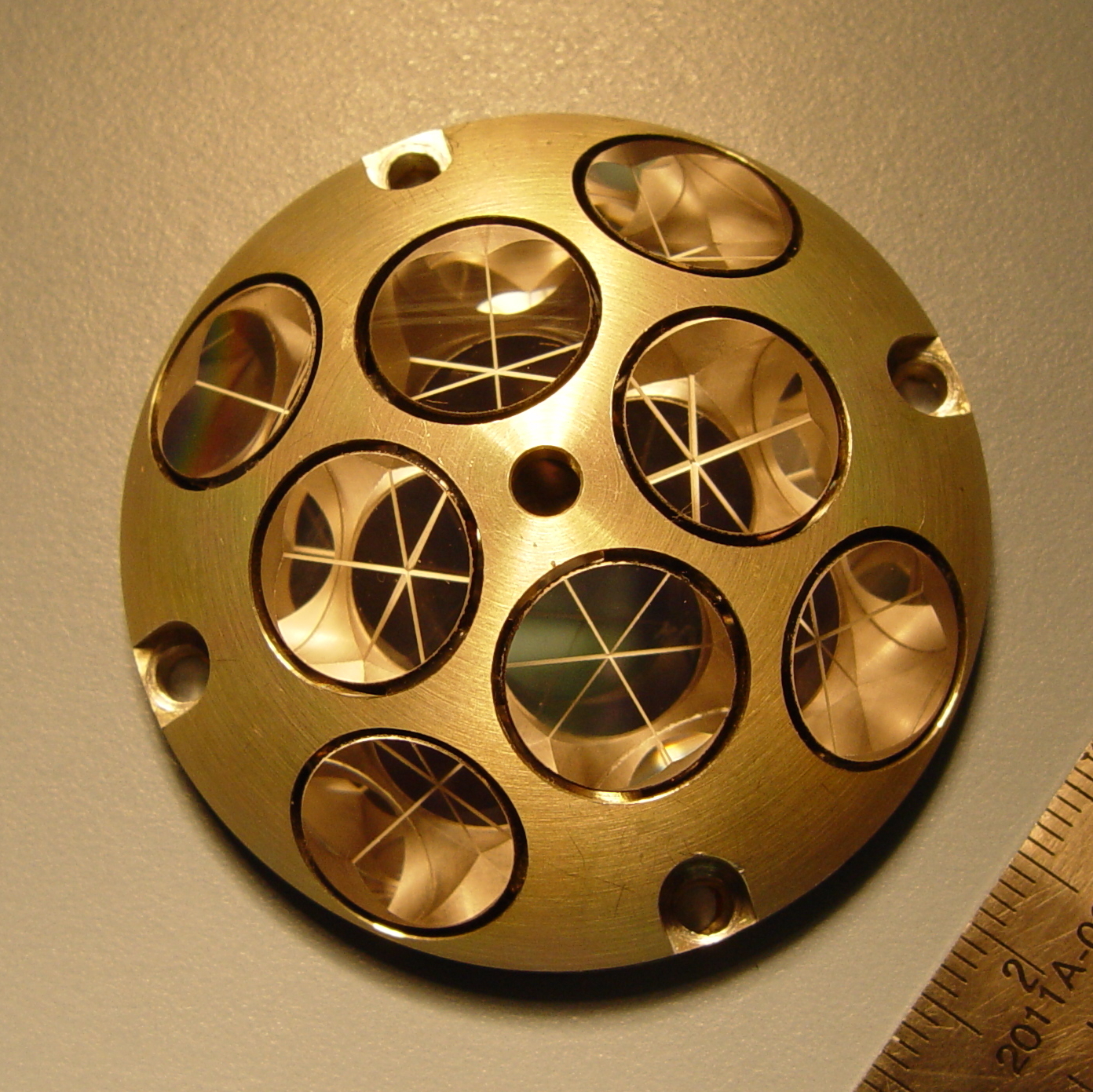 small, round, gold instrument with eight large circles 