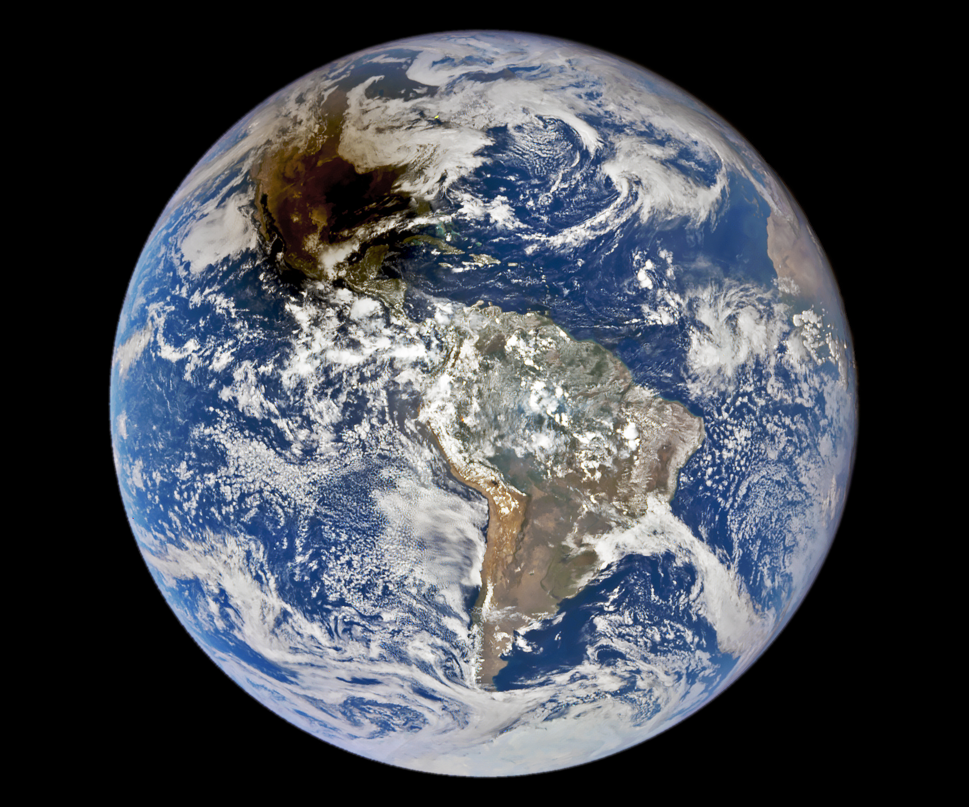 The Earth, seen from above. A dark splotch of shadow is covering much of North America.
