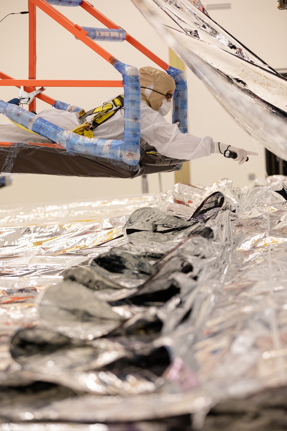 This archival image was taken in February 2021 and shows the James Webb Space Telescope's sunshield being folded and packed by engineers and technicians at Northrop Grumman.