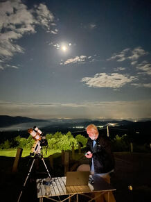 Photo of a man outside in the evening with a camera and tripod