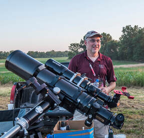 Photo of a man standing next to a large camera rig