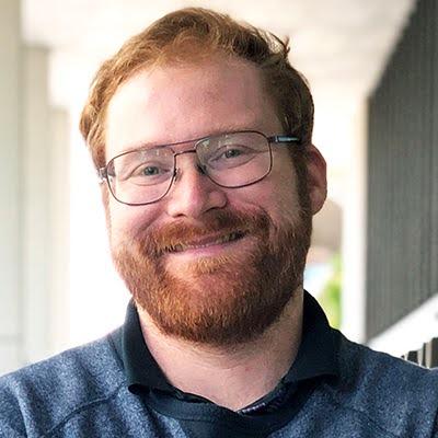 Portrait photo of a smiling man wearing glasses