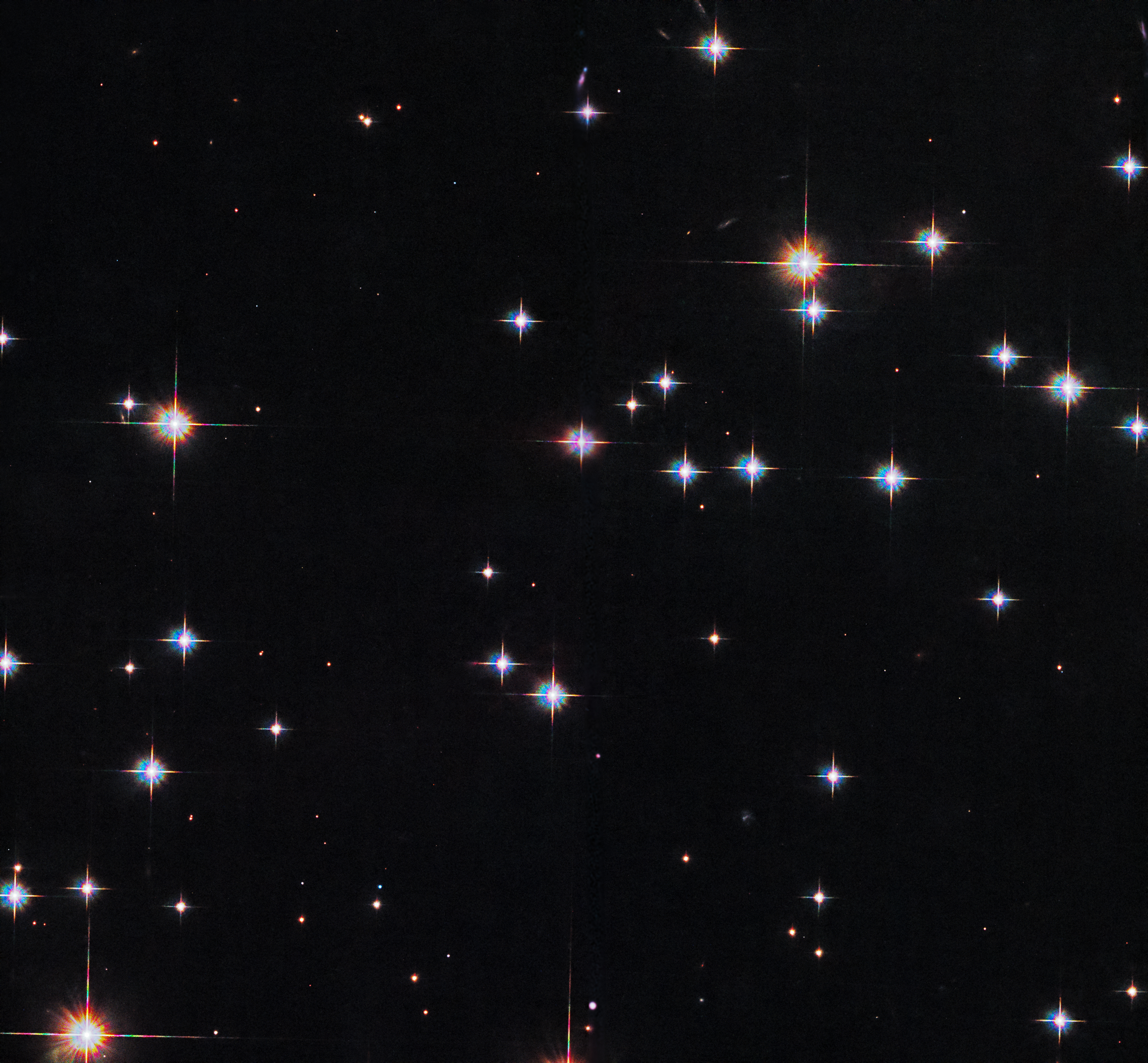 A scattering of white and reddish stars on a black background.