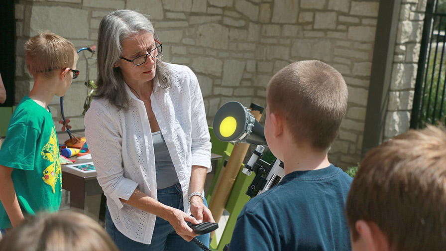 an astronomer giving a presentation to a group of small children at a library