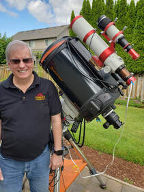 Photo of a man standing outdoors next to a large camera rig.