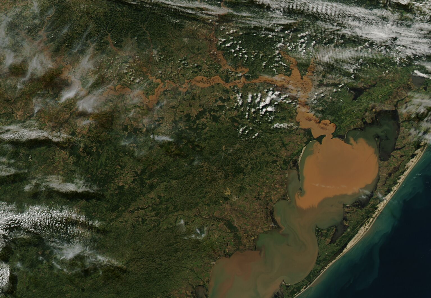 An image shows severe flooding in southern Brazil with muddy floodwater.