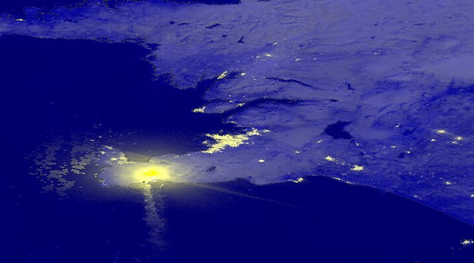 A view from orbit of a volcano glowing at night on