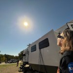 A person watching the eclipse with eclipse glasses on.