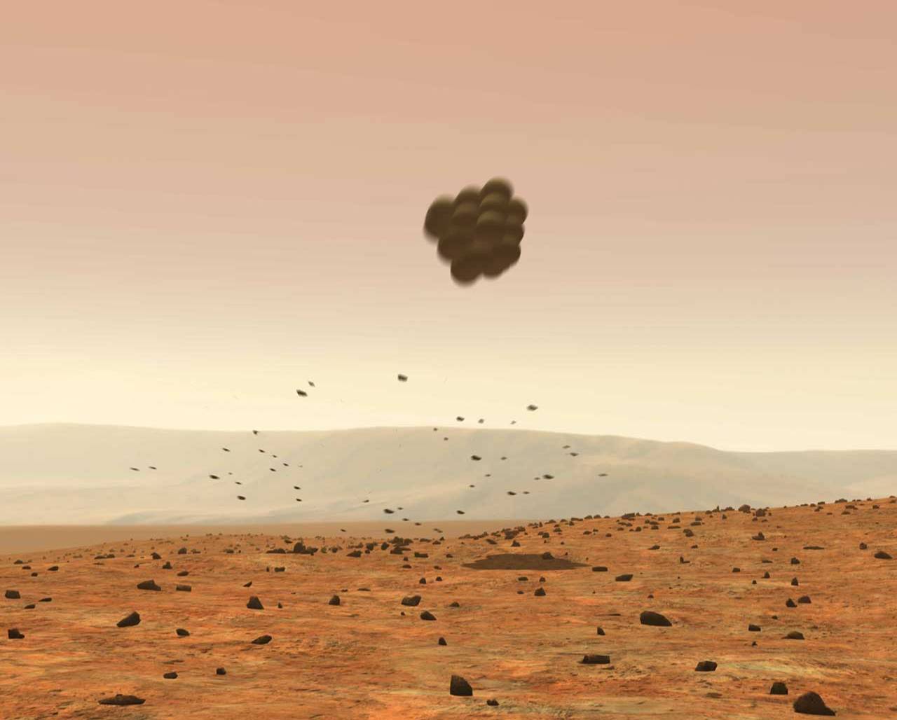 Protected by large airbags, the lander falls away from the parachute, landing safely on Mars.