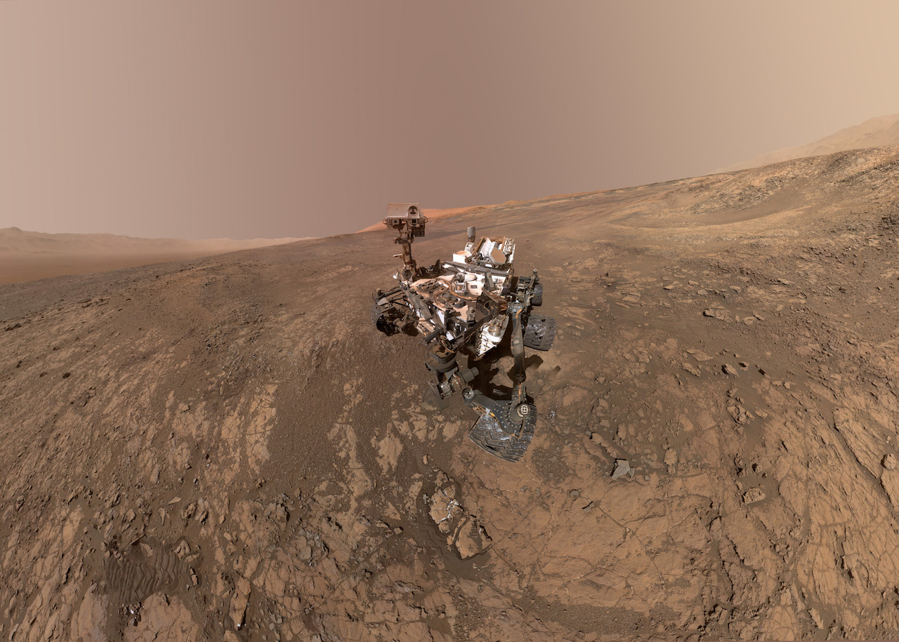 rover on mars surface with mountain in background