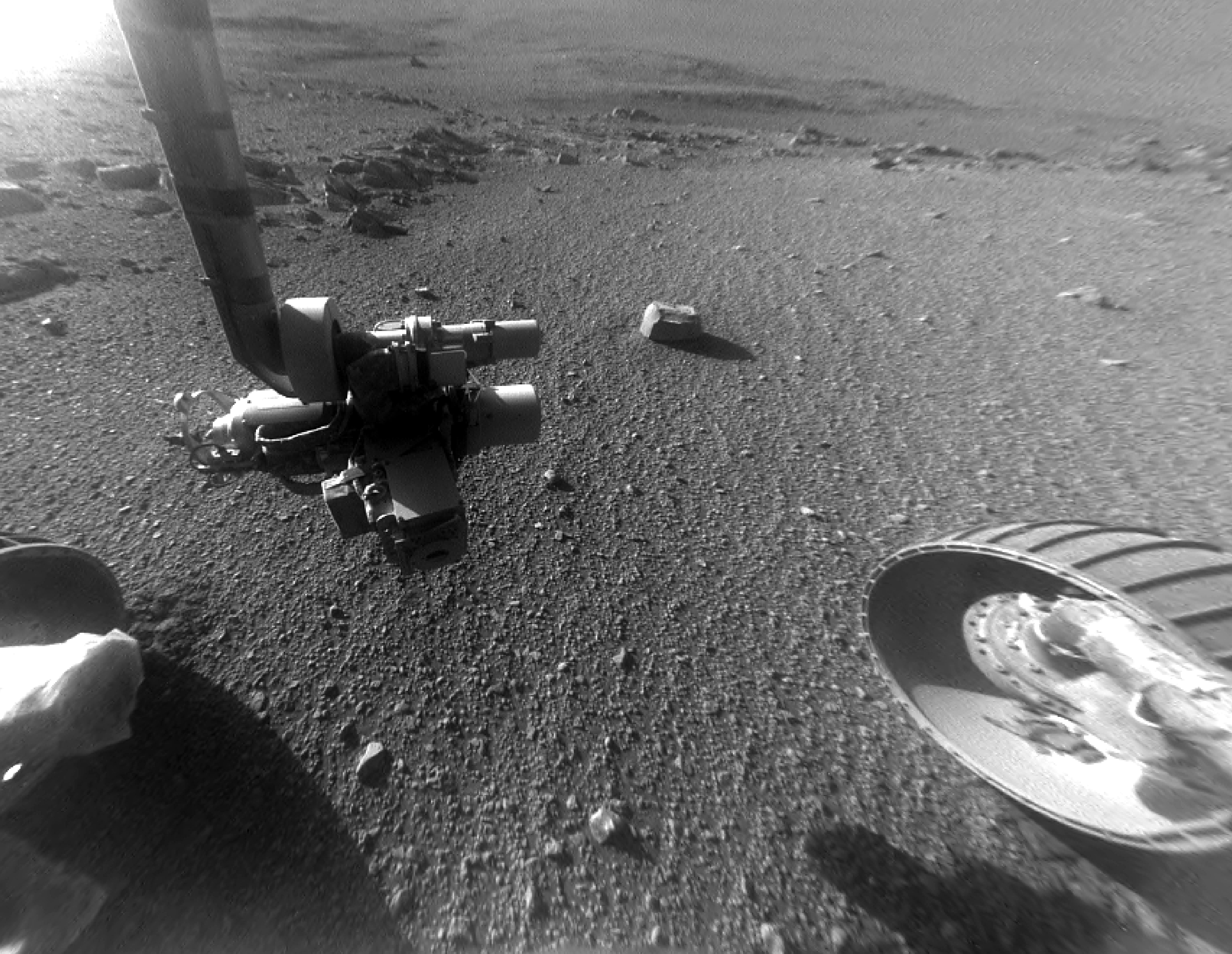 rover wheel and robot arm over rocky ground