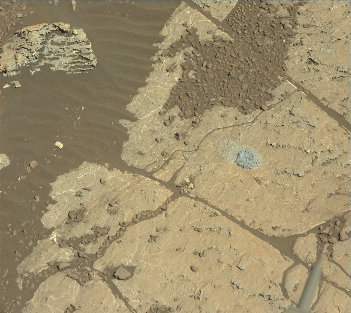 Rock surface with small drill hole and pile of drill tailings.