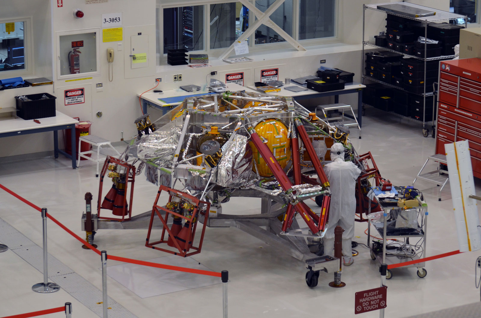 A technician working on the descent stage for NASA’s Mars 2020 mission inside JPL’s Spacecraft Assembly Facility.