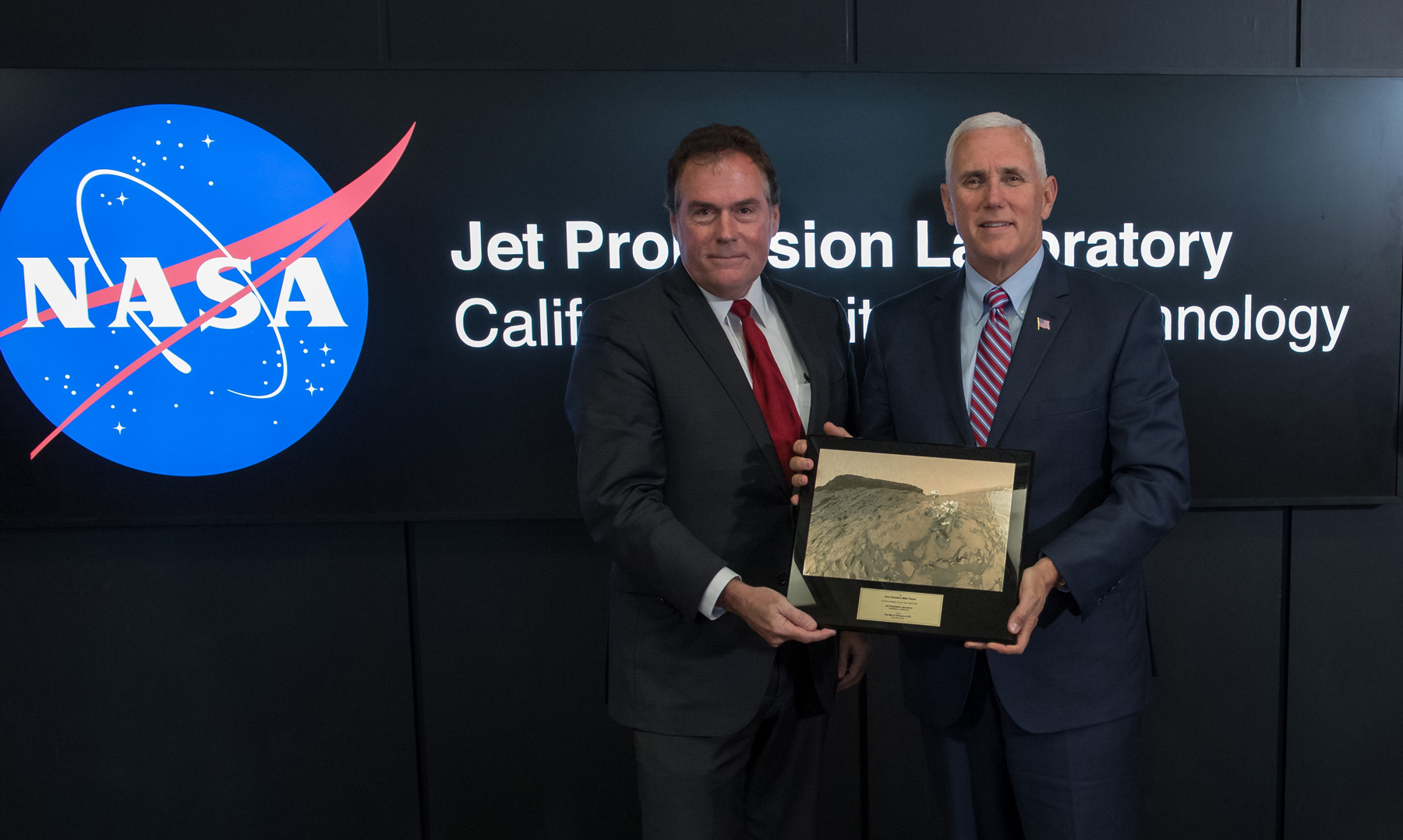 U.S. Vice President Mike Pence, right, is presented a plaque by JPL Director Michael Watkins during a tour of NASA's Jet Propulsion Laboratory, Saturday, April 28, 2018 in Pasadena, California. The plaque presents a view of the Mars Science Laboratory rover Curiosity on the surface of Mars.