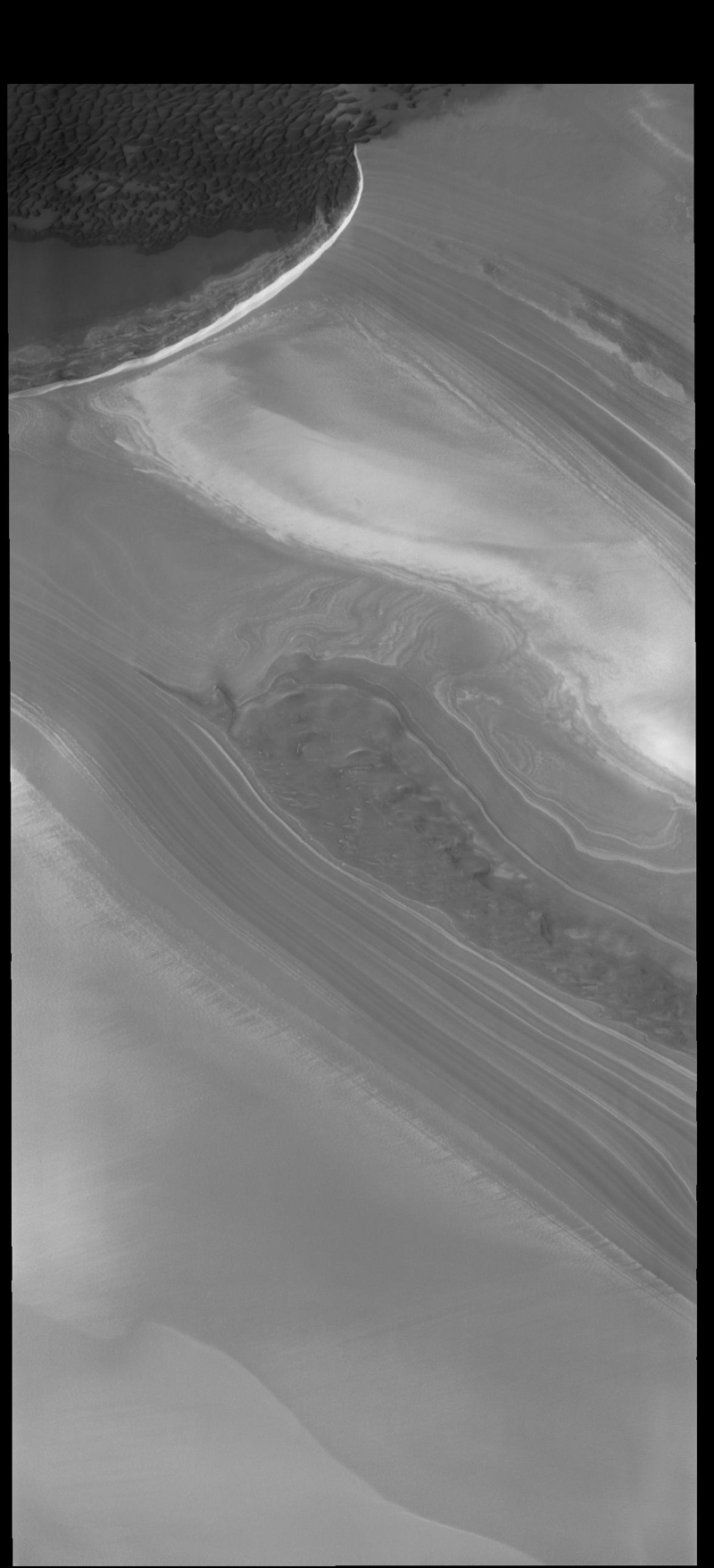 This image from NASA's 2001 Mars Odyssey spacecraft shows part of the margin of the north polar cap and the surrounding plains. The layering of the ice is easily visible due to the dust that is deposited on the top of the ice every year, creating layering over millions of years.