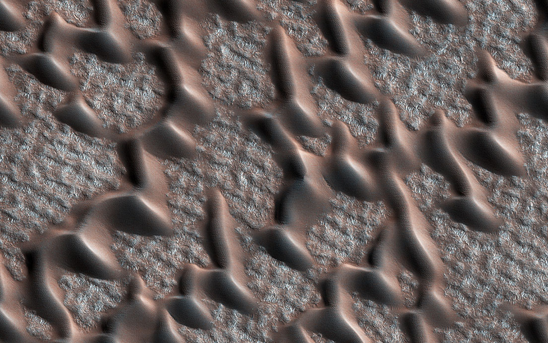 This image from NASA's Mars Reconnaissance Orbiter (MRO) shows the permanent polar cap of Mars, encircled by sand dunes and looking like pulled threads.