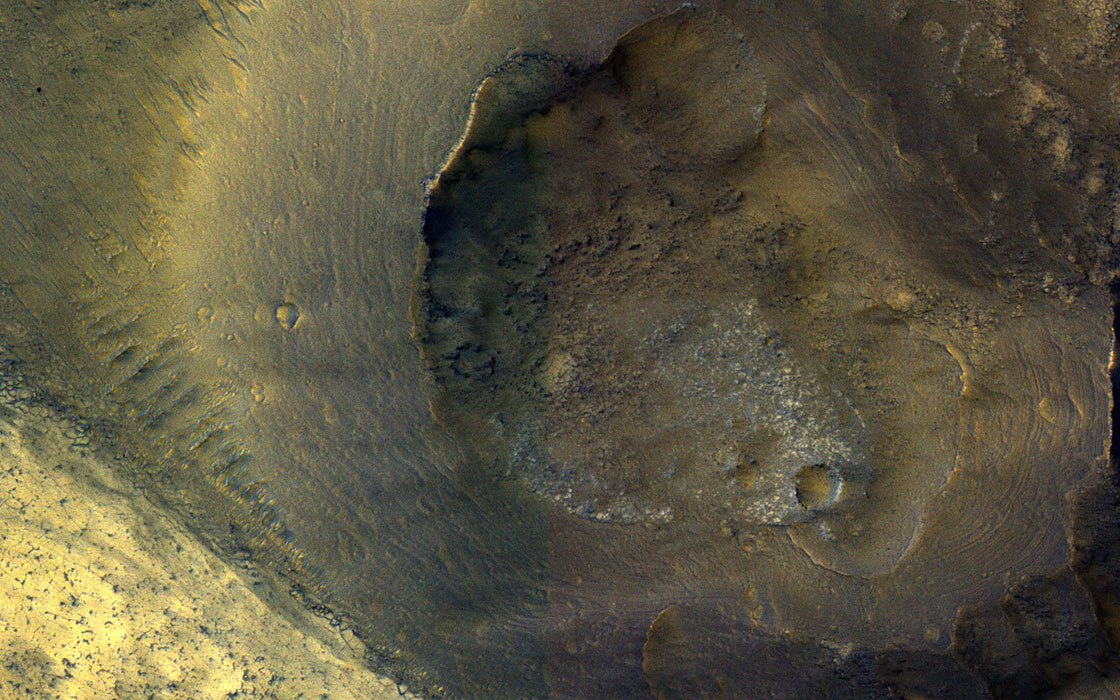 This image from NASA's Mars Reconnaissance Orbiter shows a hill with a central crater on the floor of Valles Marineris. It could be either a real volcano, the kind that erupts lava, or a sedimentary structure called a mud volcano.