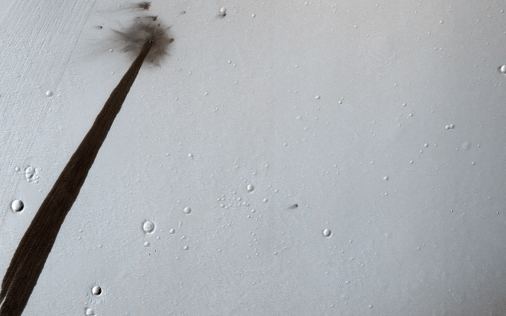 This image from NASA's Mars Reconnaissance Orbiter shows an impact crater that triggered a slope streak. When a meteoroid hit the surface and exploded to make the crater, it destabilized the slope and initiated this avalanche.