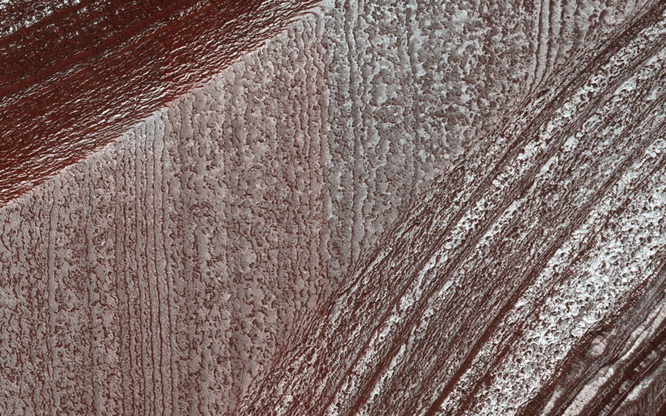 Mars' north polar deposits comprise a thick stack of icy layers. Part of this image from NASA's Mars Reconnaissance Orbiter has lingering seasonal frost, which serves to accentuate those layers.