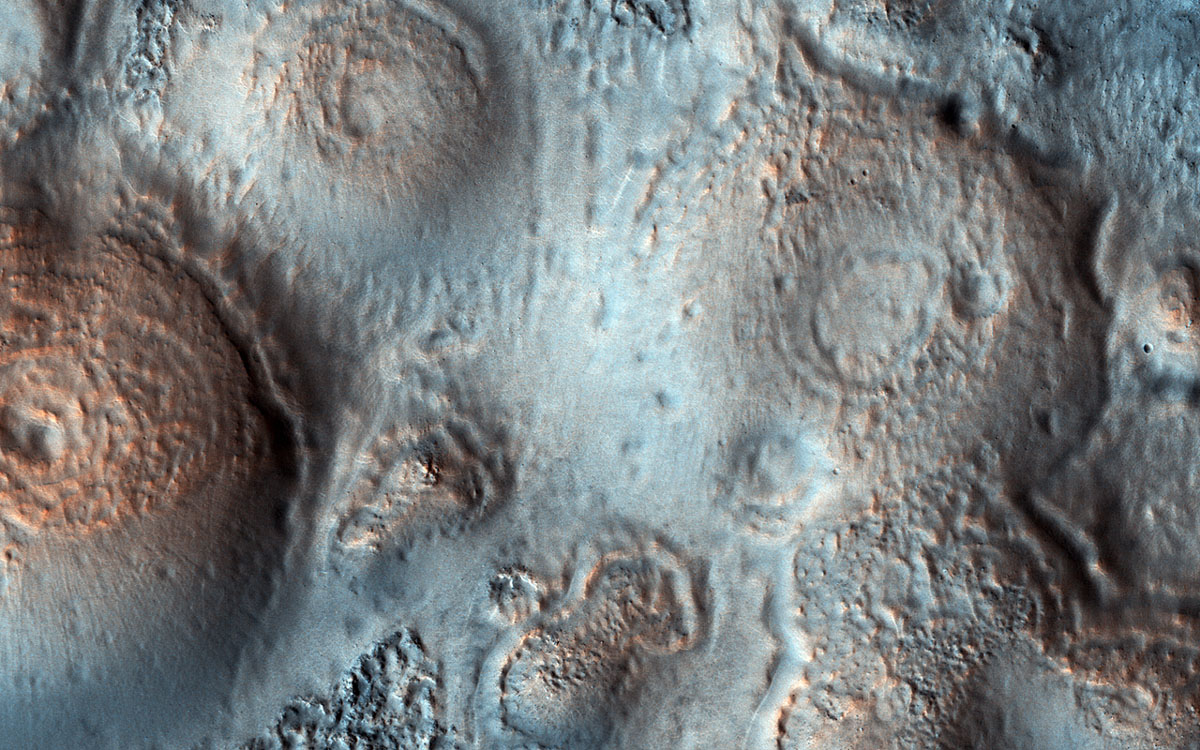 This image shows relatively bright mounds, hundreds of meters in size, scattered throughout darker and diverse surfaces in Chryse Planitia. The largest shows a central pit, similar to the collapsed craters in some Earth volcanoes.