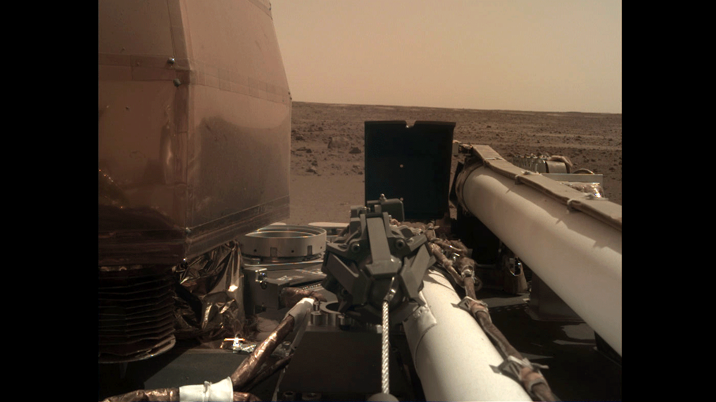 As visible in this two-frame set of images, NASA’s InSight spacecraft unlatched its robotic arm on Nov. 27, 2018, the day after it landed on Mars.
