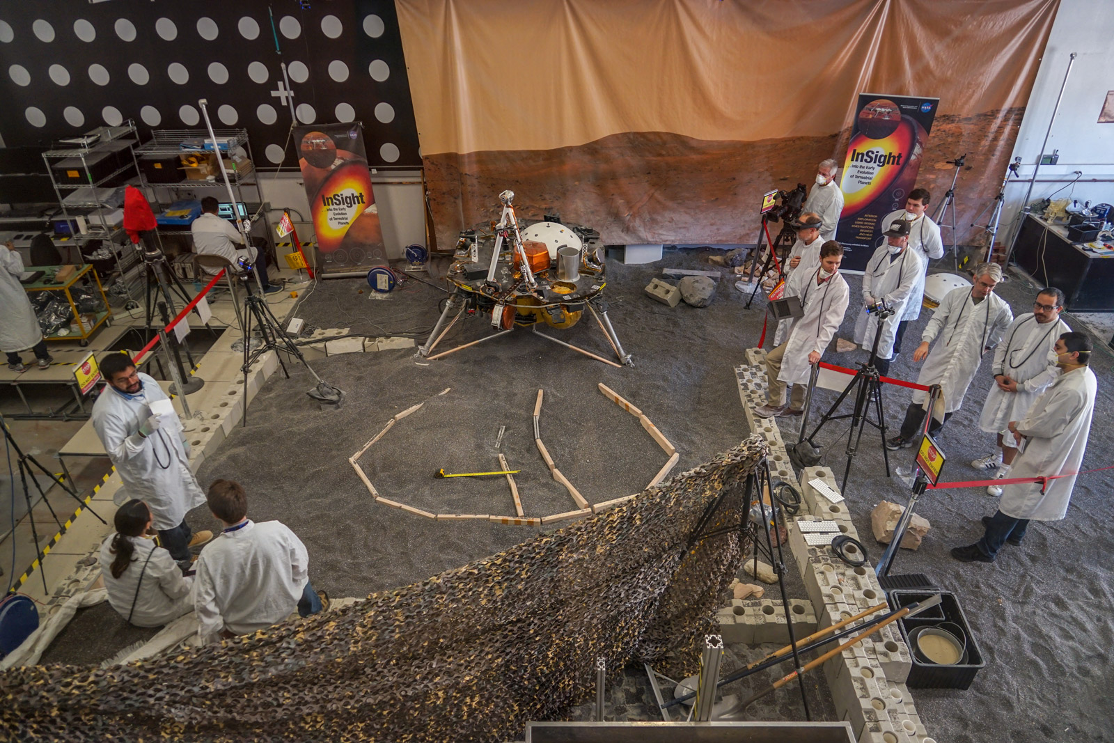 Engineers in Pasadena, California, sculpt a gravel-like material to mimic the terrain in front of NASA's InSight lander on Mars. Recreating the exact conditions will allow them to practice setting down the lander's instruments here on Earth before it's done on Mars.