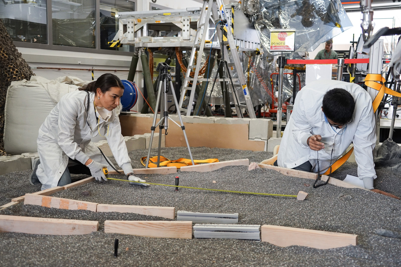 Engineers Marleen Sundgaard (left) and Pranay Mishra measure their test lander's "workspace" -- the terrain where scientists want to set InSight's instruments -- at NASA’s Jet Propulsion Laboratory in Pasadena, California.