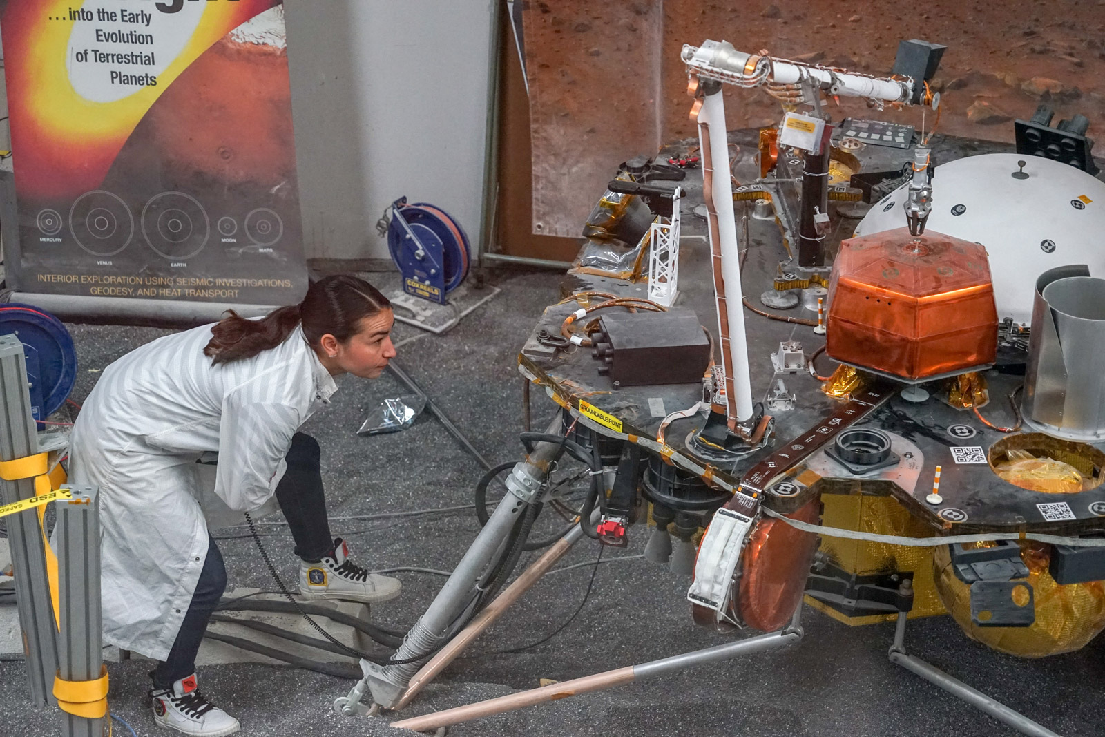 Engineer Marleen Sundgaard watches as the robotic arm on a test version of NASA's Mars InSight lander grasps a model of the spacecraft's seismometer. This work was done at NASA's Jet Propulsion Laboratory in Pasadena, California.