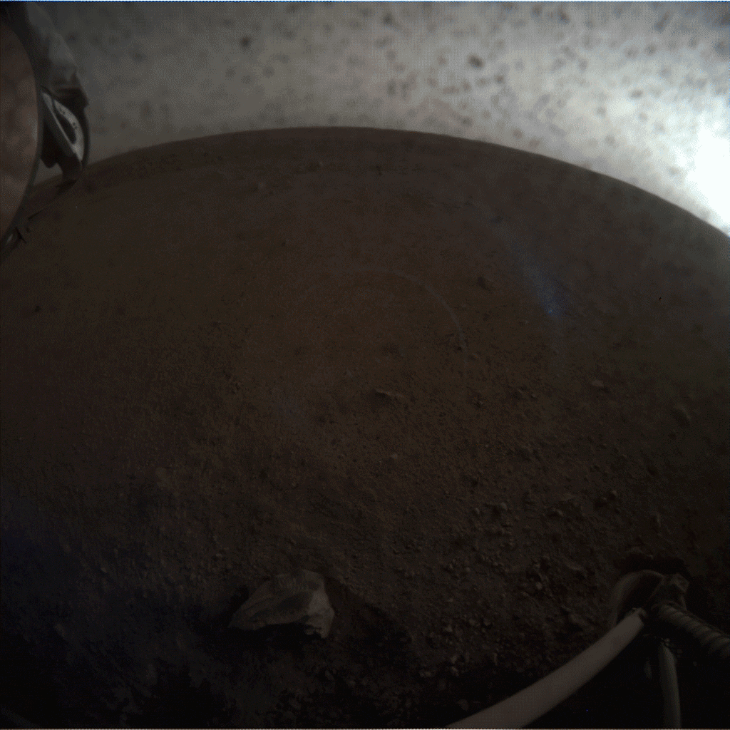 A fish-eye view of NASA's InSight lander deploying its first instrument onto the surface of Mars, taken by the spacecraft's Instrument Context Camera (ICC) on Dec. 19, 2018.