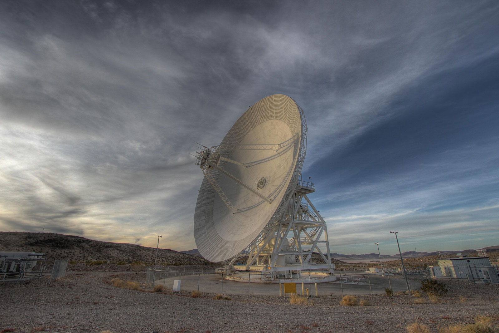 A Goldstone 111.5-foot (34-meter) beam-waveguide antenna tracks a spacecraft as it comes into view. The Goldstone Deep Space Communications Complex is located in the Mojave Desert in California.