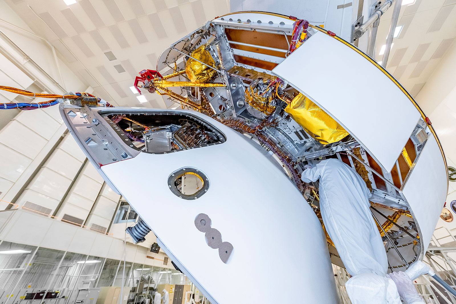 A member of NASA's Mars 2020 project checks connections between the spacecraft's back shell and cruise stage.