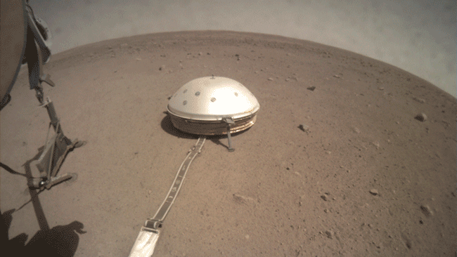 On June 28, 2019, NASA's InSight lander used its robotic arm to move the support structure for its digging instrument, informally called the "mole." This view was captured by the fisheye Instrument Context Camera under the lander's deck.