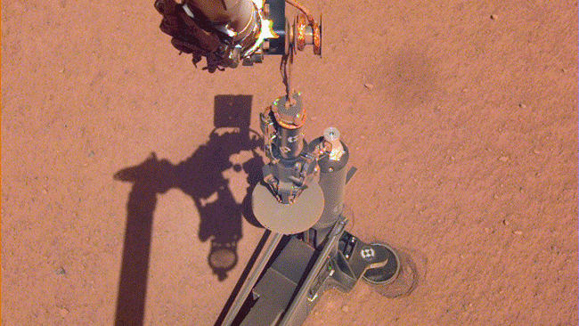 On June 28, 2019, NASA's InSight lander used its robotic arm to move the support structure for its digging instrument, informally called the "mole." This view was captured by the Instrument Deployment Camera on the spacecraft's robotic arm.