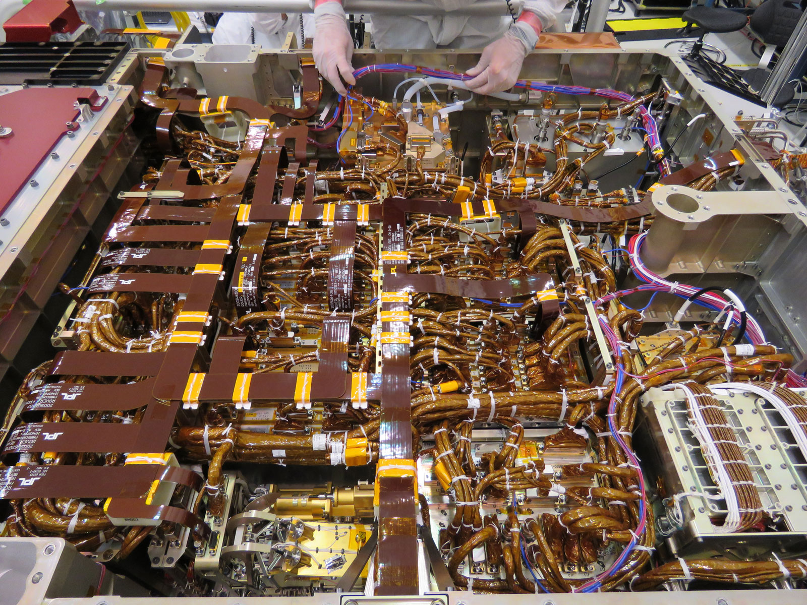 In this image, taken on June 1, 2019, an engineer in the Spacecraft Assembly Facility's High Bay 1 at NASA’s Jet Propulsion Laboratory in Pasadena, California, works on the exposed belly of the Mars 2020 rover. It has been inverted to allow the 2020 engineers and technicians easier access.