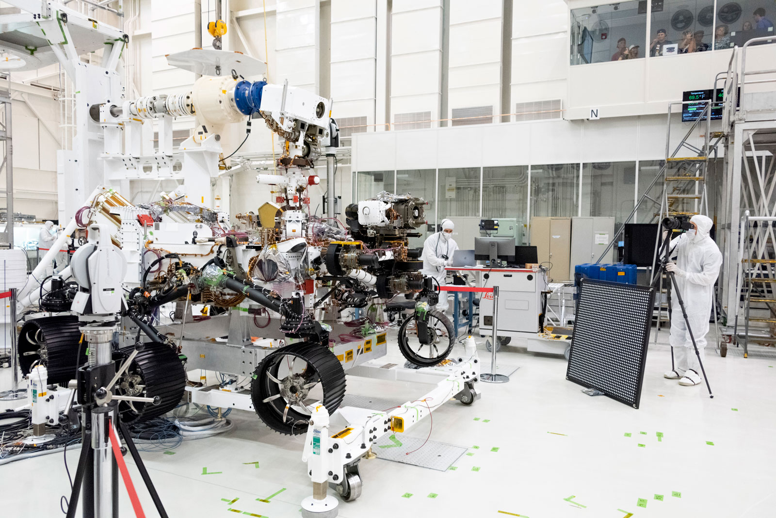 In this image, engineers test cameras on the top of the Mars 2020 rover’s mast and front chassis.