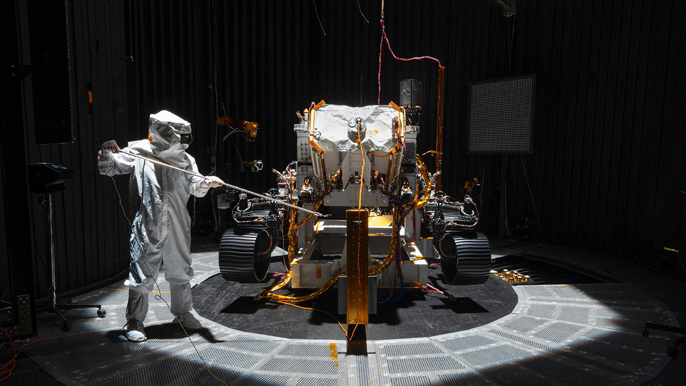 An engineer working on NASA's Mars 2020 mission uses a solar intensity probe to measure and compare the amount of artificial sunlight that reaches different portions of the rover.