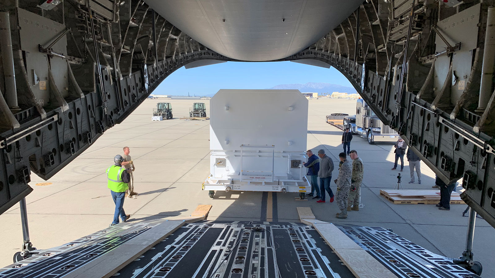 The shipping container carrying NASA's Mars 2020 rover is readied for loading aboard an Air Force C-17 transport plane at March Air Reserve Base in Riverside, California, on Feb. 11, 2020.