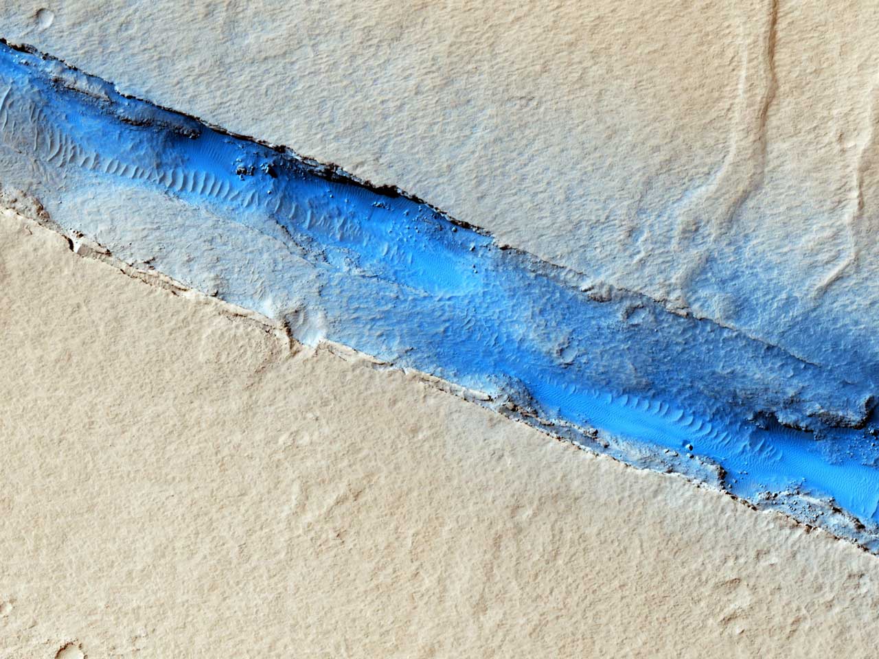 The linearity of the volcanic vent shown in this HiRISE image, in conjunction with evidence of lava flow from the vent, suggests control by combined volcano-tectonic processes.