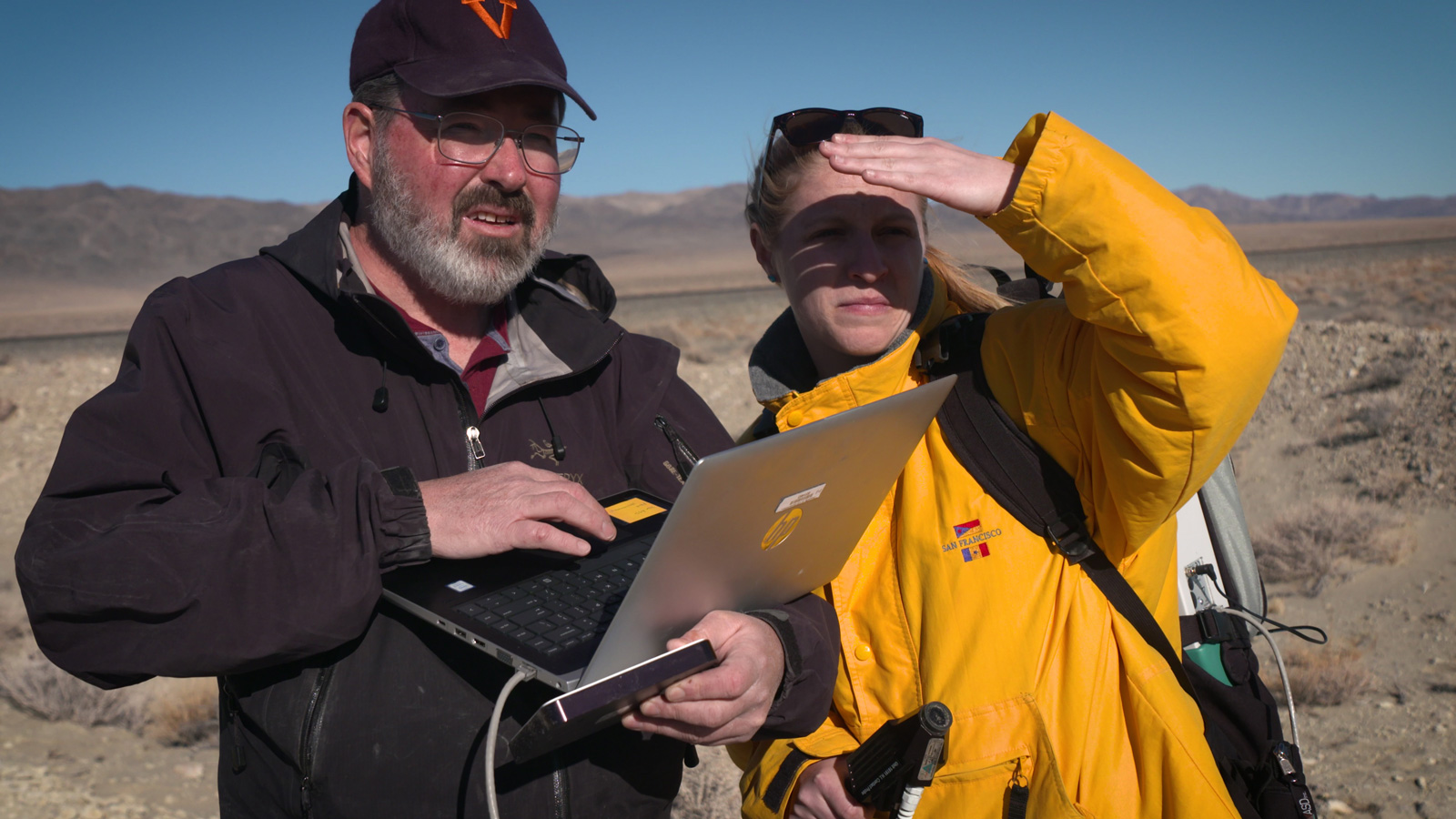 Two JPL scientists in a dry lakebed in the Nevada desert