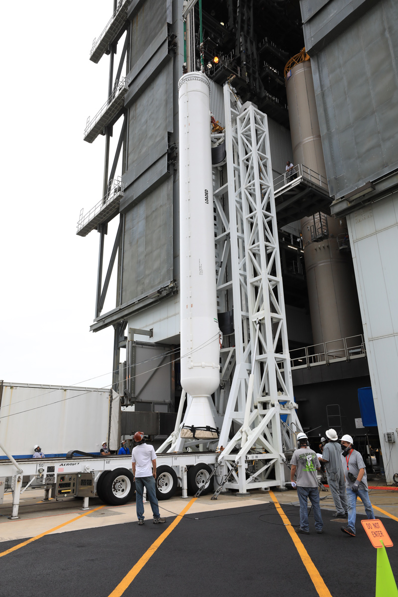 A crane is attached to the second of four solid rocket boosters for the Atlas V rocket at KSC